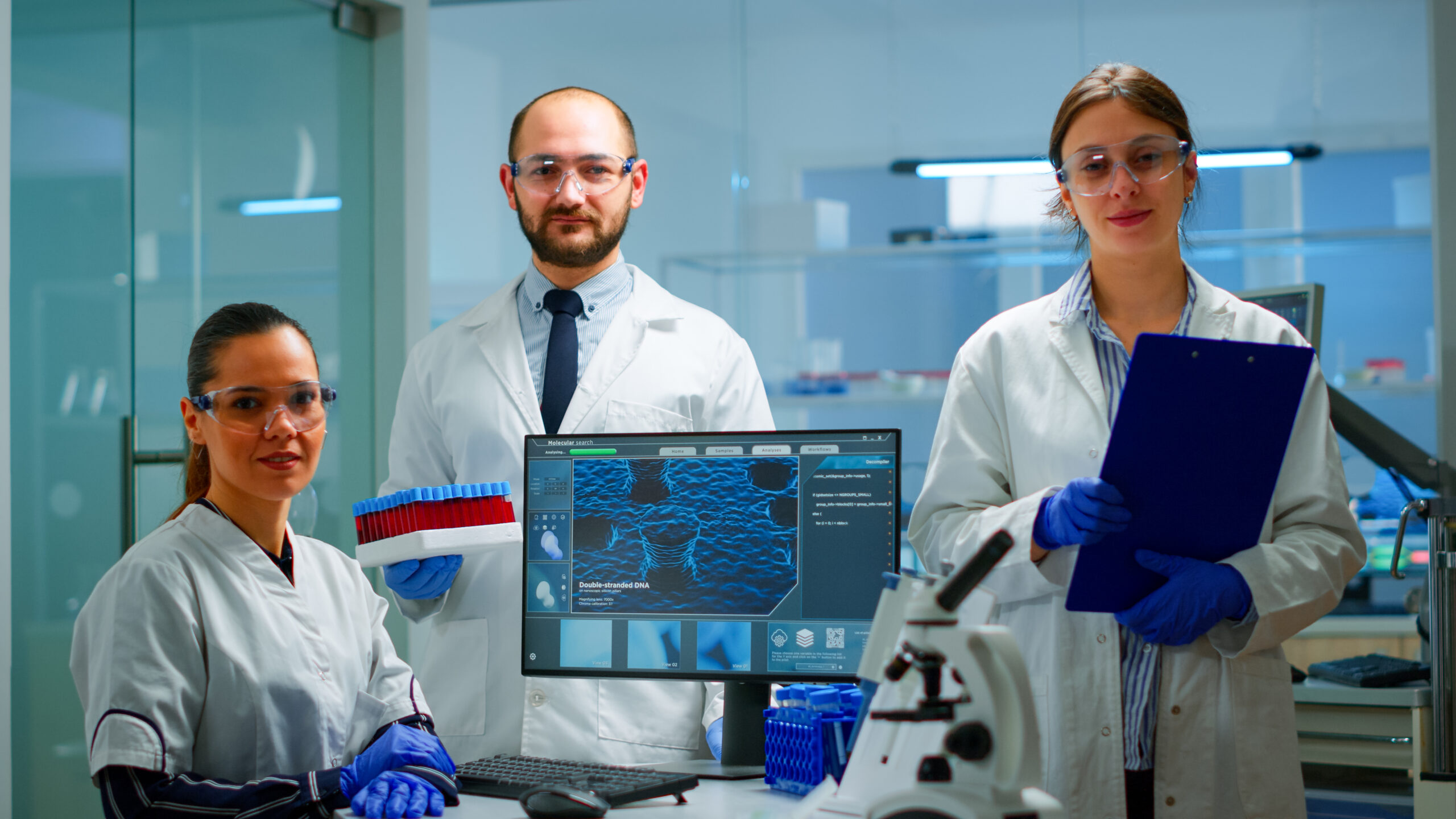Professional scientific medical staff looking at camera in modern equipped lab. Team of doctors examining virus evolution with high tech, chemistry tools for scientific research, vaccine development